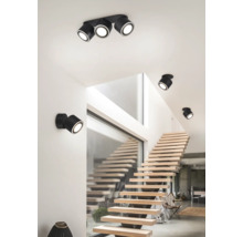 Scenă cu o scară luminoasă și mai multe spoturi negre pe tavan și perete