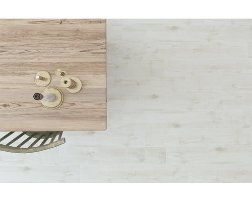 Plăci de podea deschise la culoare cu aspect de lemn, montate într-o cameră cu o masă de lemn și decorațiuni