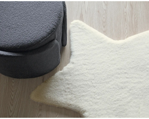 Aranjament decorativ cu un taburet gri și un covor alb în formă de stea