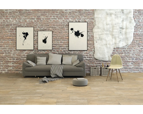 Living cu canapea, scaun și decorațiuni de perete în fața unui zid de cărămidă