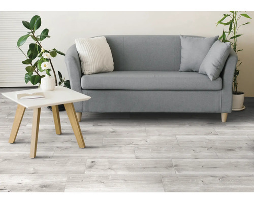 Living luminos cu canapea, masă și podea cu gresie aspect lemn.