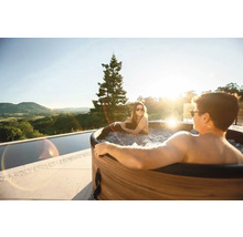 Cuplu se relaxează într-o cadă cu vedere spre peisaj