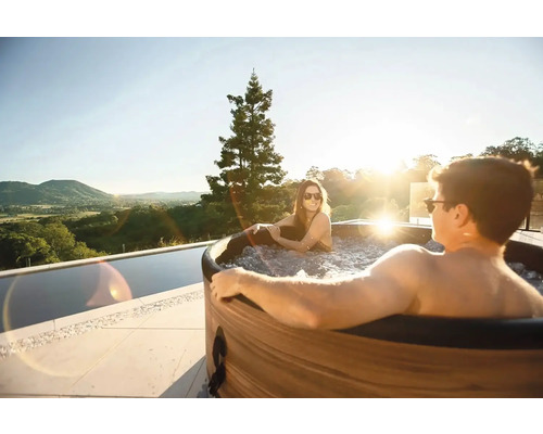 Cuplu se relaxează într-o cadă cu vedere spre peisaj