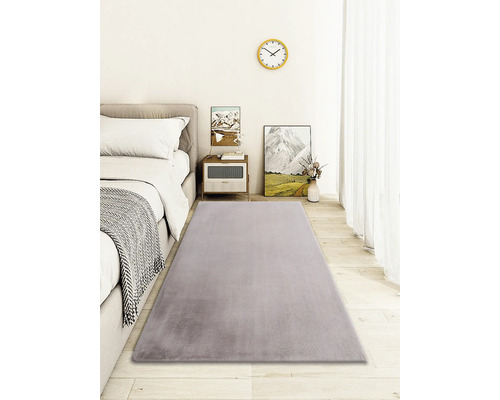 Covor gri în dormitor cu pat, noptieră și decorațiuni