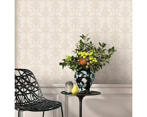 Perete decorativ cu tapet cu model floral, completat de o masă cu o vază cu flori și fructe.