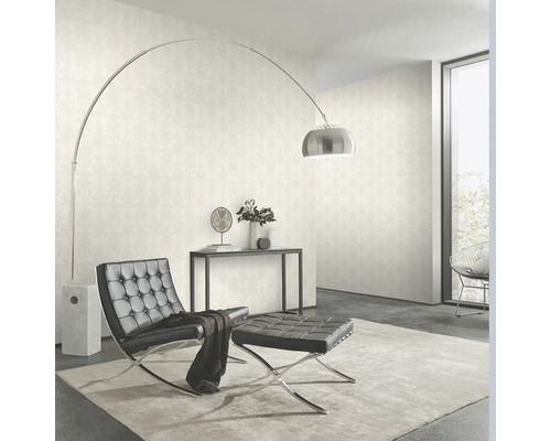 Cameră de zi cu tapet, fotoliu, taburet și lampă de podea.