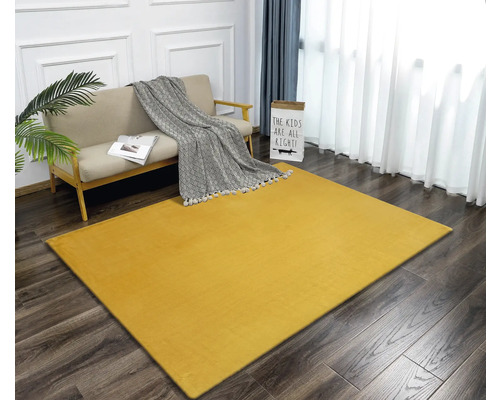 Covor galben într-un living cu canapea și decorațiuni