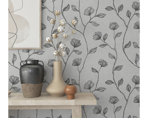 Decor de perete cu tapet floral și vaze decorative pe o masă.