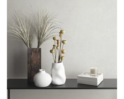 Natură statică decorativă cu vaze, ierburi ornamentale, ramuri decorative și lumânare pe o consolă