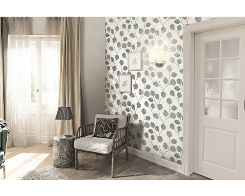 Cameră de zi cu tapet cu frunze, fotoliu și ușă