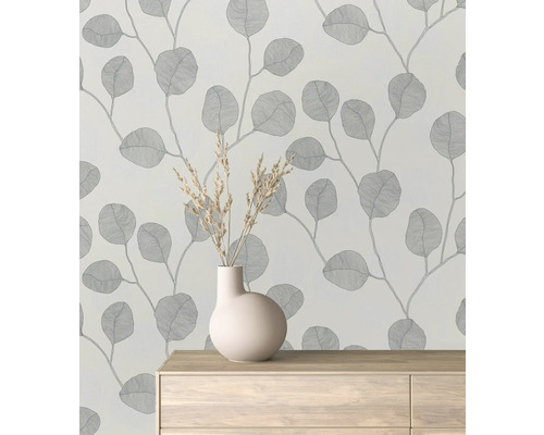 Tapetă cu model de frunze într-o cameră cu o vază pe o comodă.