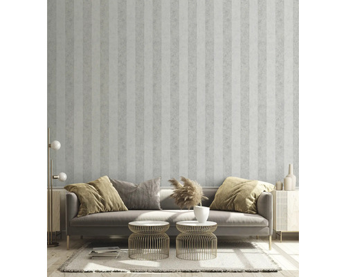 Cameră de zi cu tapet cu dungi, canapea, măsuțe laterale și elemente decorative pentru o ambianță stilată.