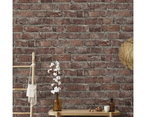 Perete cu tapet imitație cărămidă și elemente decorative precum scară, geantă, pălărie, vază și masă