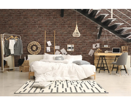 Dormitor cu pat, birou și scară în fața unui perete de cărămidă