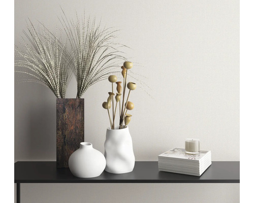 Scenă decorativă cu vaze, flori uscate, lumânare și carte pe o consolă