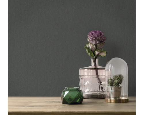 Accesorii decorative pe o masă în fața unui tapet întunecat