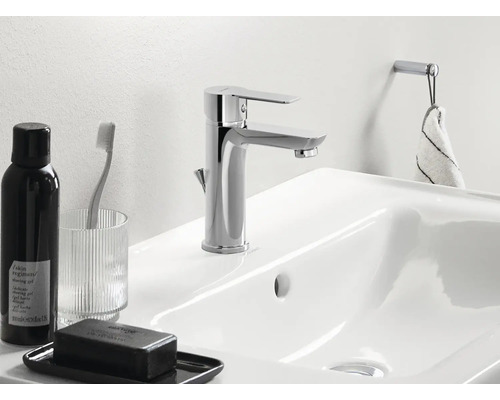 Imagine detaliată a unei chiuvete cu robinet, săpun, suport pentru periuța de dinți și suport pentru prosop