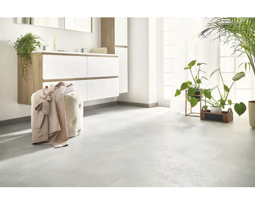 Baie luminoasă cu lavoar, oglindă, taburet cu halat de baie și plante de interior.