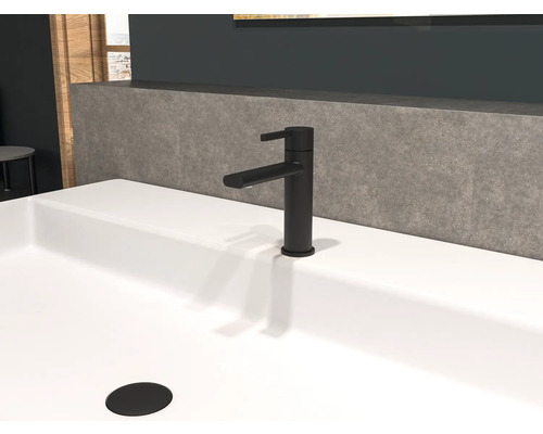 Baterie neagră de lavoar pe o chiuvetă albă