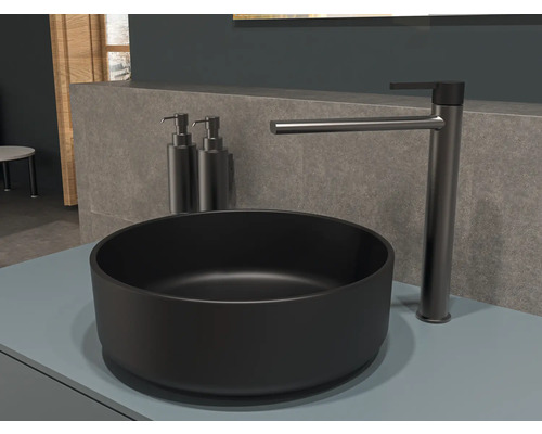 Lavoar negru pe blat cu baterie și două dispensere de săpun în baie