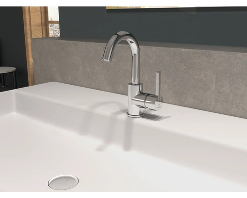 Pe o chiuvetă se află un robinet strălucitor.