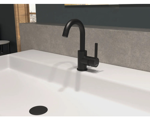 Baterie neagră de lavoar pe o chiuvetă albă