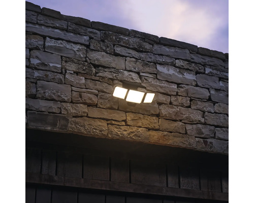 Lumină de perete cu trei spoturi LED pe un perete de piatră