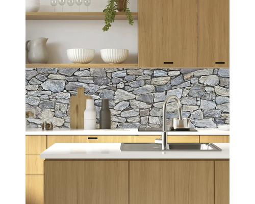Protecție perete bucătărie cu motiv de zid de piatră într-o bucătărie luminoasă cu elemente din lemn