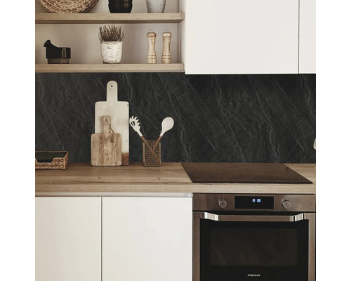 Bucătărie modernă cu blat de lucru, protecție de perete cu aspect de piatră și ustensile de bucătărie