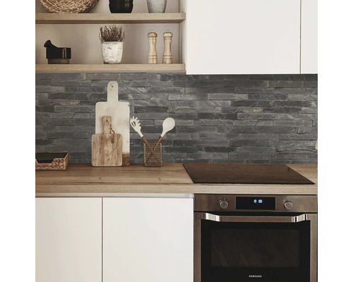 Vedere a bucătăriei cu blat de lucru, perete de piatră și cuptor încorporat