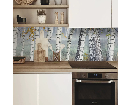 Scenă de bucătărie cu bucătărie încorporată albă, blat de lucru din lemn și perete posterior cu motiv de pădure de mesteacăn