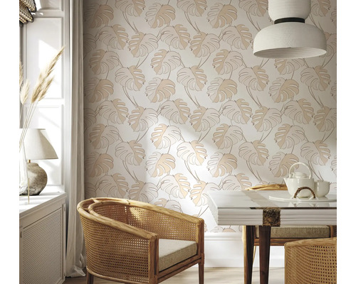 Sufragerie luminoasă cu tapet cu frunze de monstera, scaun din ratan și masă de sufragerie.