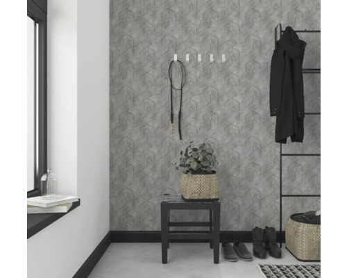 Hol cu tapetă geometrică, scaun, plantă și dulap