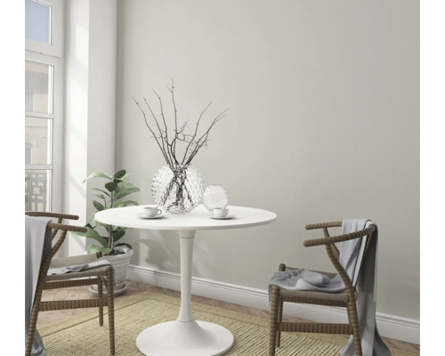 Colț de luat masa luminos și primitor cu masă rotundă, două scaune, decorațiuni și plantă de interior.