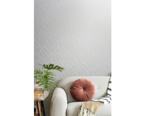 Living cu tapet cu model, canapea și elemente decorative.