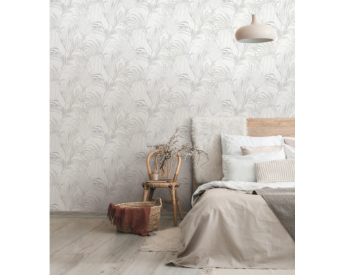 Un dormitor cu un perete decorat cu un tapet cu model floral, un pat și un scaun.