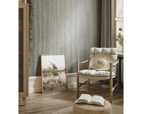 Cameră de zi cu tapet texturat, fotoliu și decorațiuni pentru o ambianță luminoasă și confortabilă.