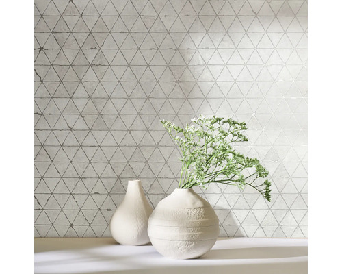 Faianță decorativă cu model triunghiular și două vaze pe un raft.