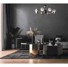 Sufragerie cu canapea, masă și plantă de interior sub o lampă decorativă