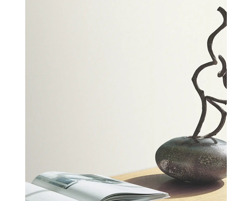 Cameră luminoasă cu carte, decorațiune și vază pe o masă