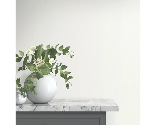 Vază decorativă cu flori și frunze pe o placă de marmură