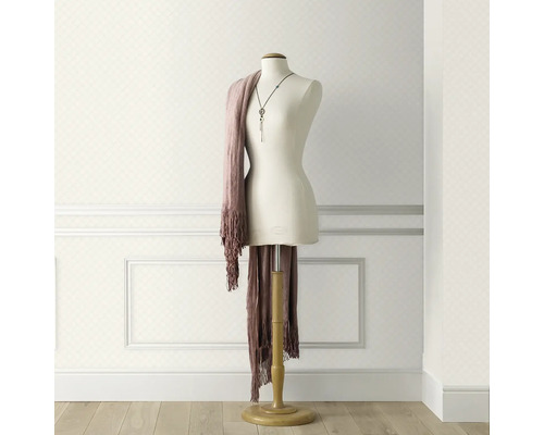 Tapetă deschisă la culoare cu model de romburi în cameră cu manechin de croitorie și eșarfă