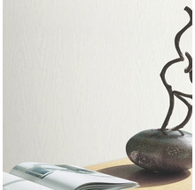 Tapetă deschisă la culoare cu aspect de lemn pe o decorațiune de masă cu o carte și o sculptură