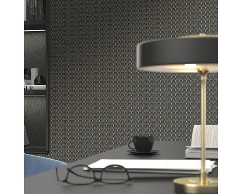 Prim-plan cu un perete cu tapet în stil art deco, completat de un birou cu o lampă, ochelari, o ceașcă de cafea și cărți.