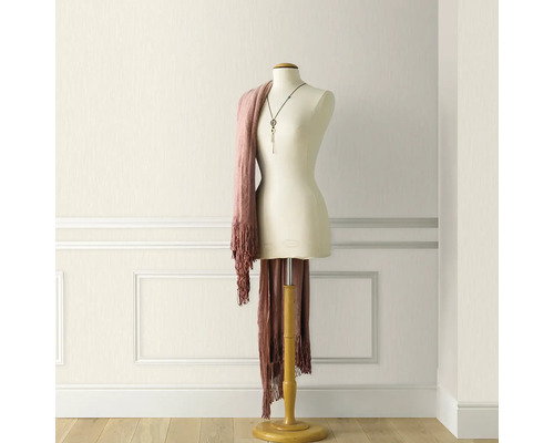 Cameră luminoasă cu tapet texturat și manechin de croitorie cu eșarfă