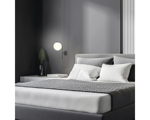 Dormitor cu pat, noptieră și lampă de perete