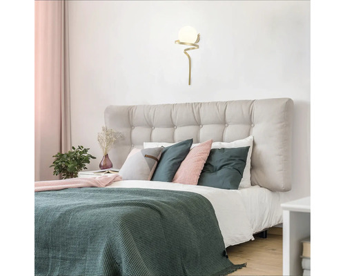 Dormitor cu pat, perne și lampă de perete cu glob de sticlă