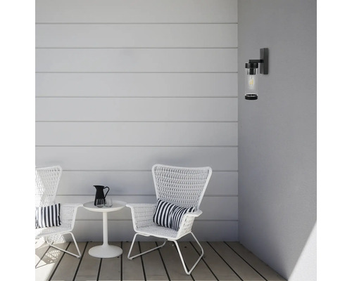 Terasa cu două scaune din ratan, o măsuță laterală și o lampă de perete