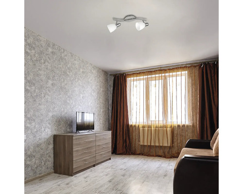 Cameră de zi cu plafonieră, comodă, televizor, fereastră și canapea