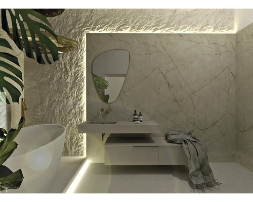 Baie modernă cu cadă, dulap sub lavoar, oglindă și placare de perete cu aspect de piatră naturală.